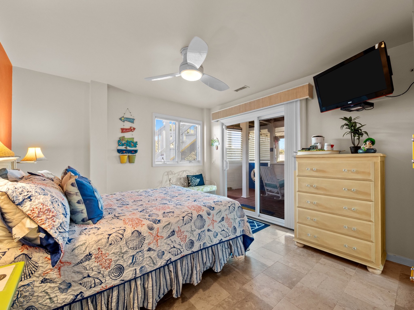 Rest peacefully in your cheerful bedroom with coastal touches, ceiling fan comfort, and private balcony access for morning sea breezes.