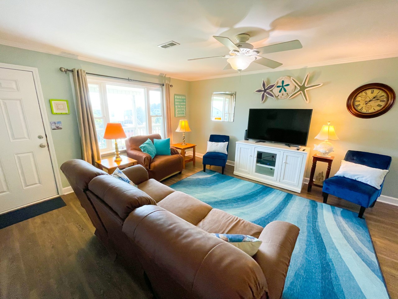 Sink into plush sectional seating while ocean waves beneath your feet inspire coastal dreams in this cheerful living space.