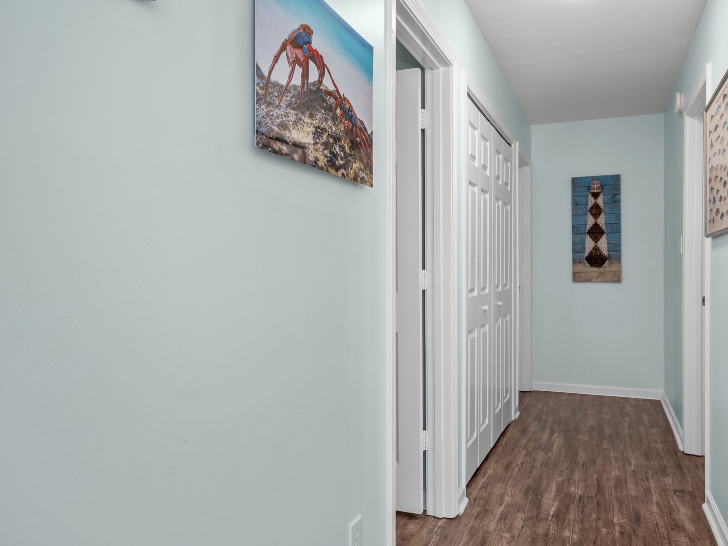 Step into your peaceful hallway, where coastal artwork and soothing blue walls create a calming retreat after your beach adventures.