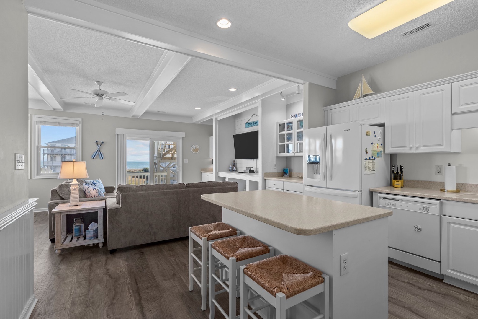 Your coastal kitchen flows seamlessly into the living area, where you can cook while chatting with family and enjoying glimpses of the ocean beyond.