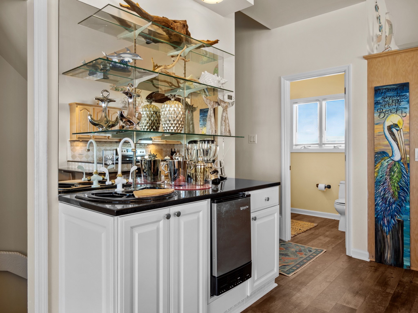 Prepare your favorite meals in this beautifully equipped kitchen featuring sleek granite counters, modern appliances, and stunning glass shelving.