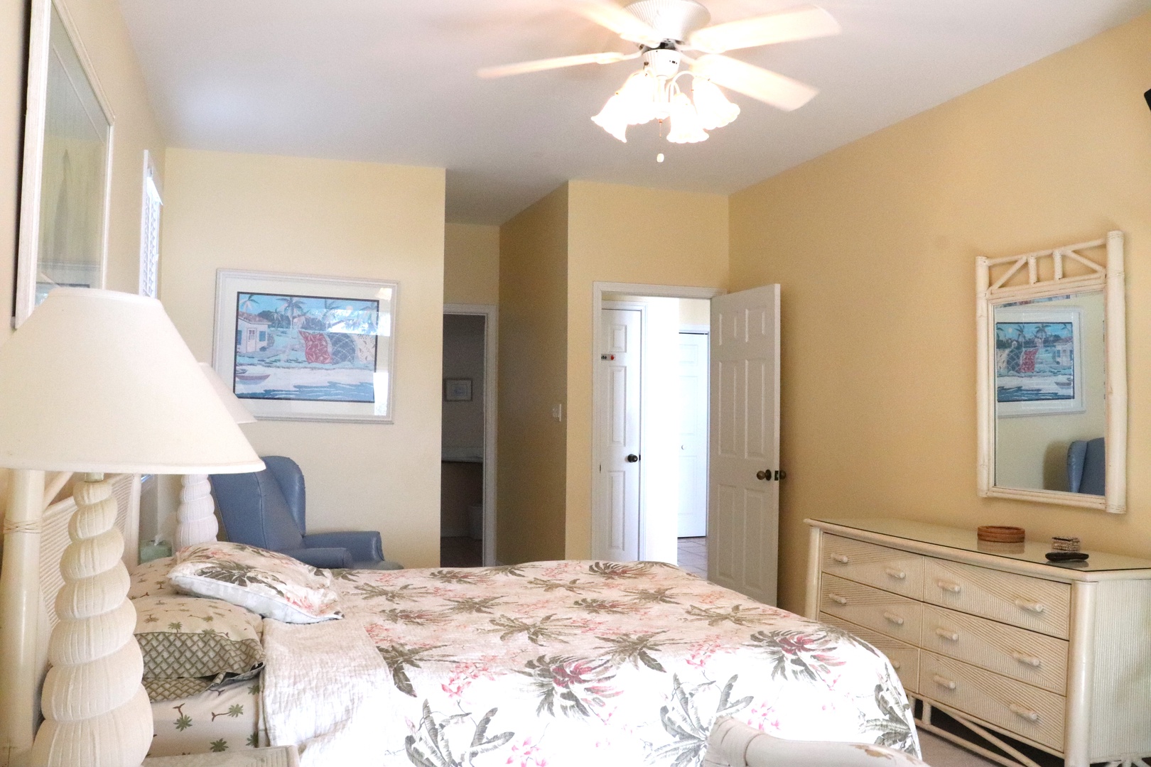 Unwind in your peaceful bedroom with coastal charm, featuring a plush bed and gentle ceiling fan for perfect comfort.