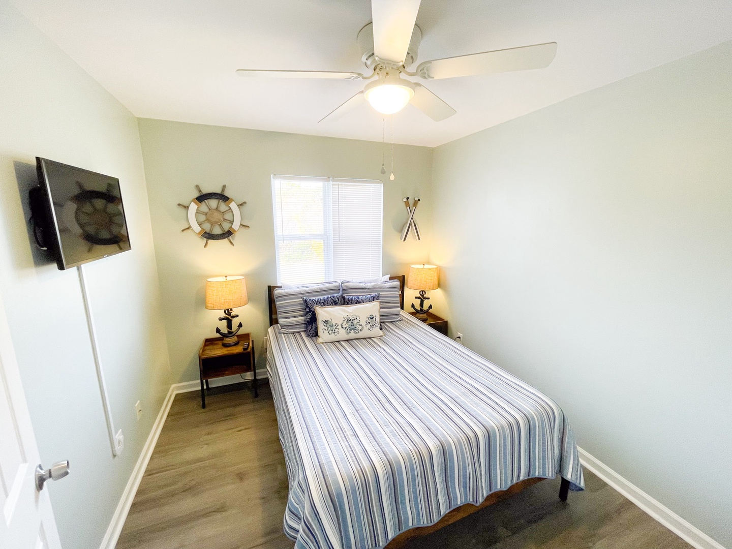 Your cozy nautical bedroom features a comfortable bed with crisp striped linens and charming coastal decor to lull you to peaceful sleep.