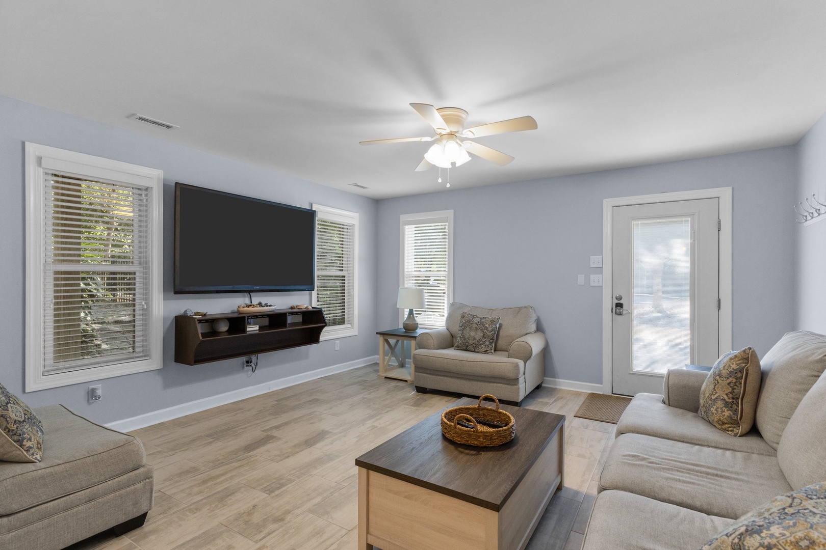 Unwind in your spacious living room with plush seating, modern entertainment, and soothing blue walls that create the perfect atmosphere for relaxation.