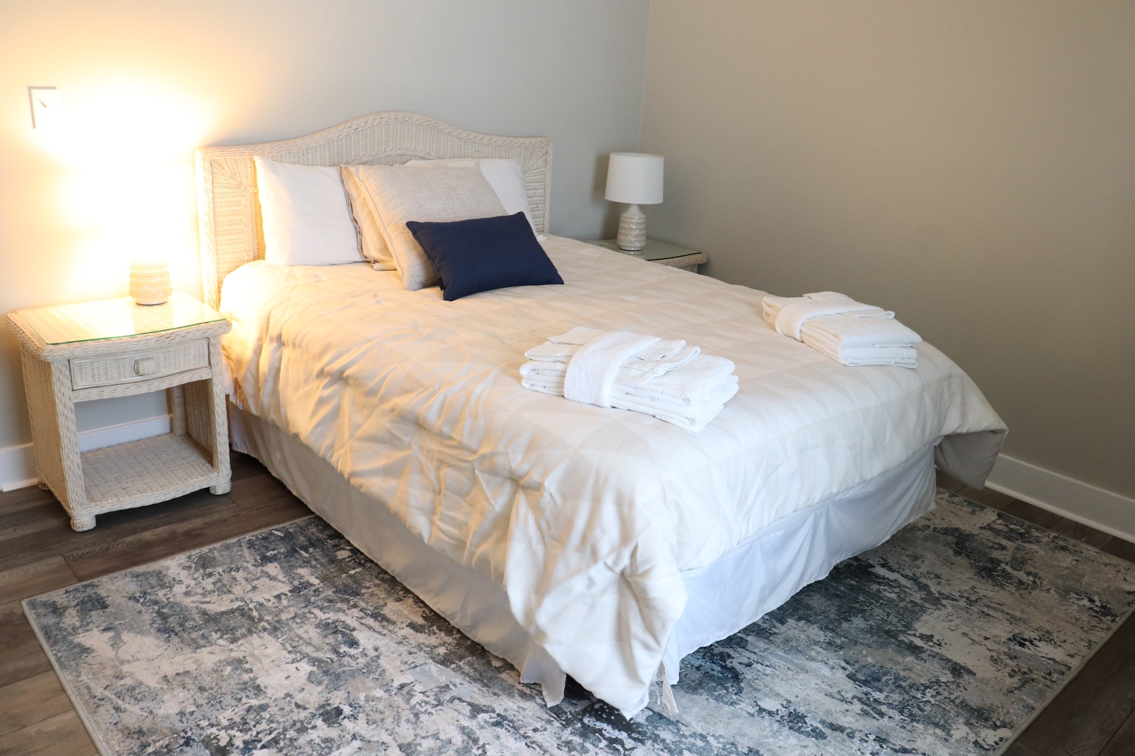 Sink into crisp white linens and coastal charm in your serene bedroom, complete with fresh towels and warm bedside lighting.