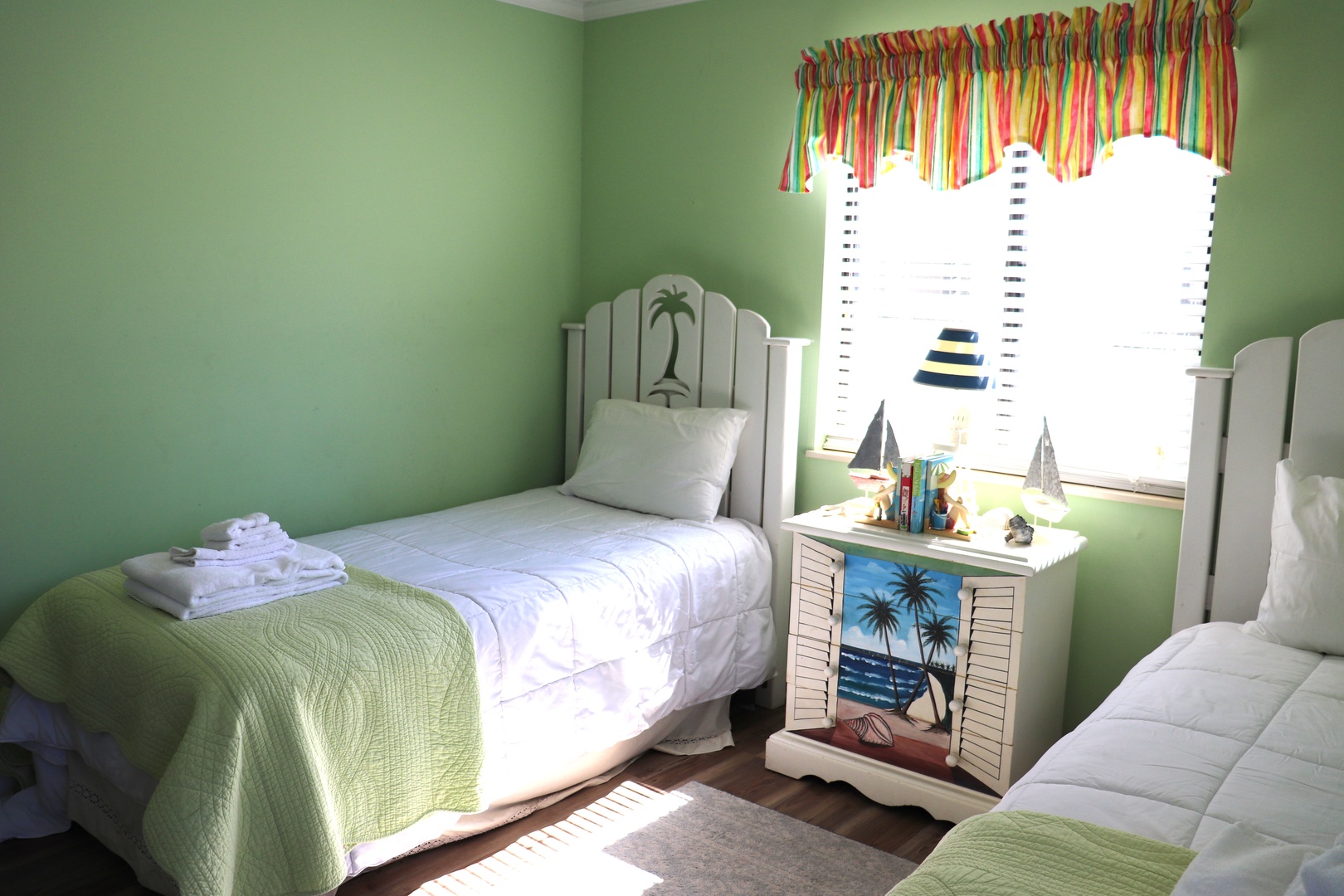 Sleep peacefully in your tropical twin bedroom with cheerful green walls, palm-themed decor, and fresh linens waiting for you.