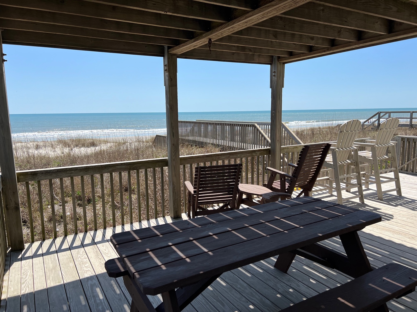 Your private deck overlooks pristine white sand and rolling waves, where morning coffee tastes better and sunset views create unforgettable memories.