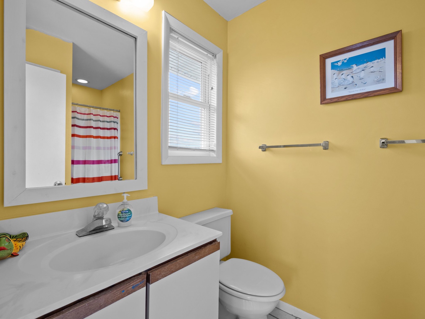 Your bright, cheerful bathroom features a spacious vanity and welcoming yellow walls that create a sunny, uplifting atmosphere for your daily routine.