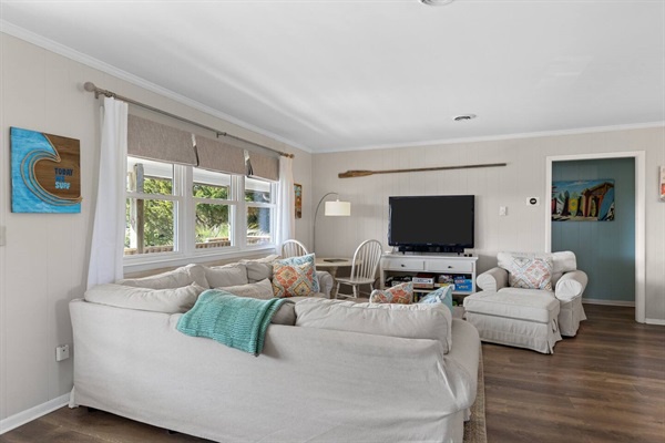 Sink into this cozy living room where soft furnishings meet coastal charm. Natural light streams through windows as you relax on plush sofas.