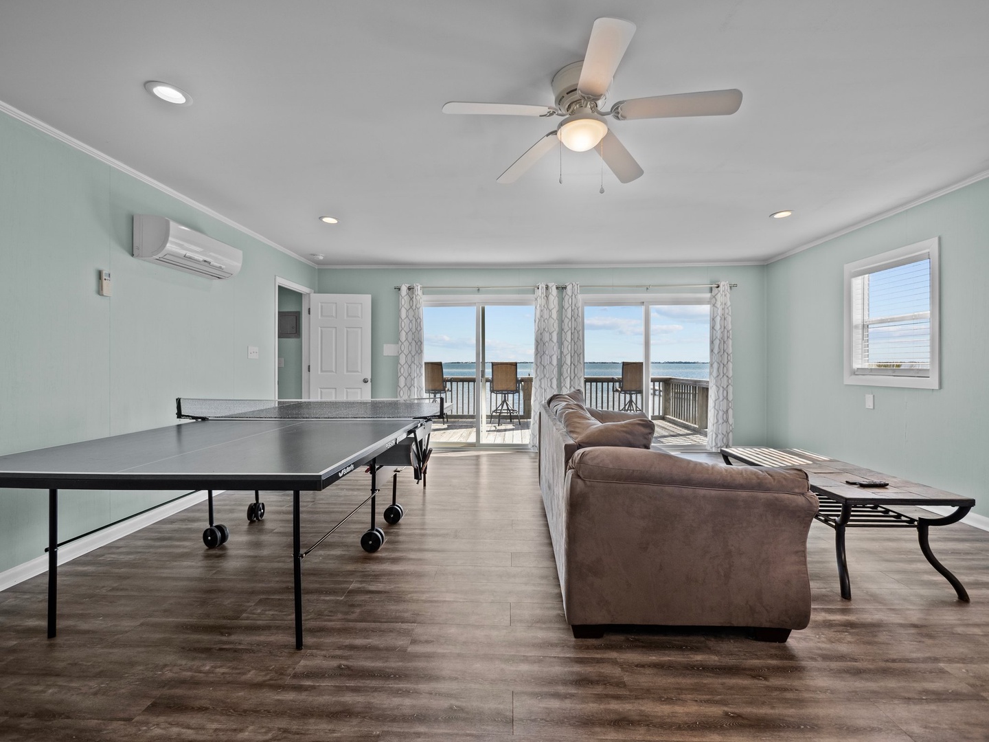 Your oceanfront game room features ping pong fun with stunning sea views through floor-to-ceiling windows—perfect for friendly competition.