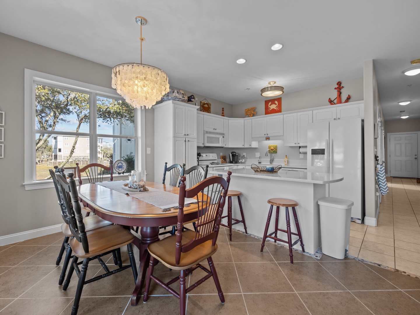 Gather around your spacious kitchen island where sparkling chandeliers create perfect ambiance for memorable meals with loved ones.