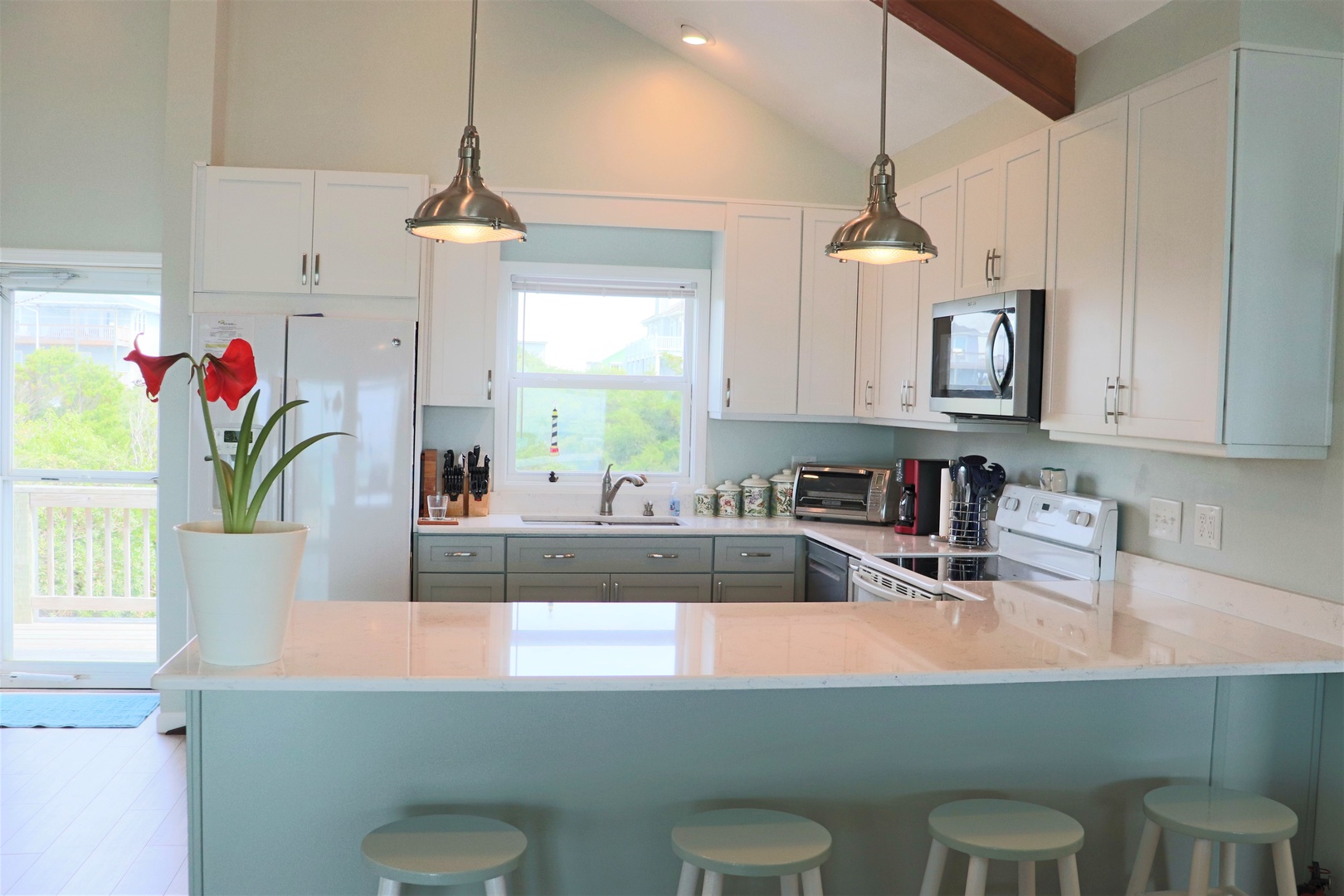 Your bright, modern kitchen features gleaming countertops, pendant lighting, and everything you need to create memorable meals during your stay.