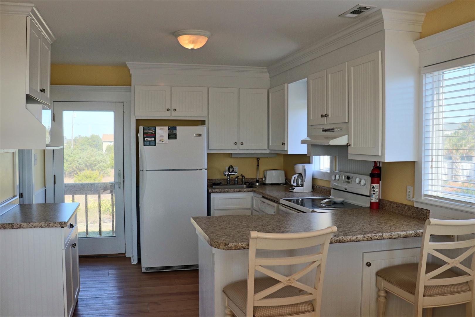 Your bright, fully-equipped kitchen awaits with granite counters, white cabinets, and everything you need for home-cooked meals.