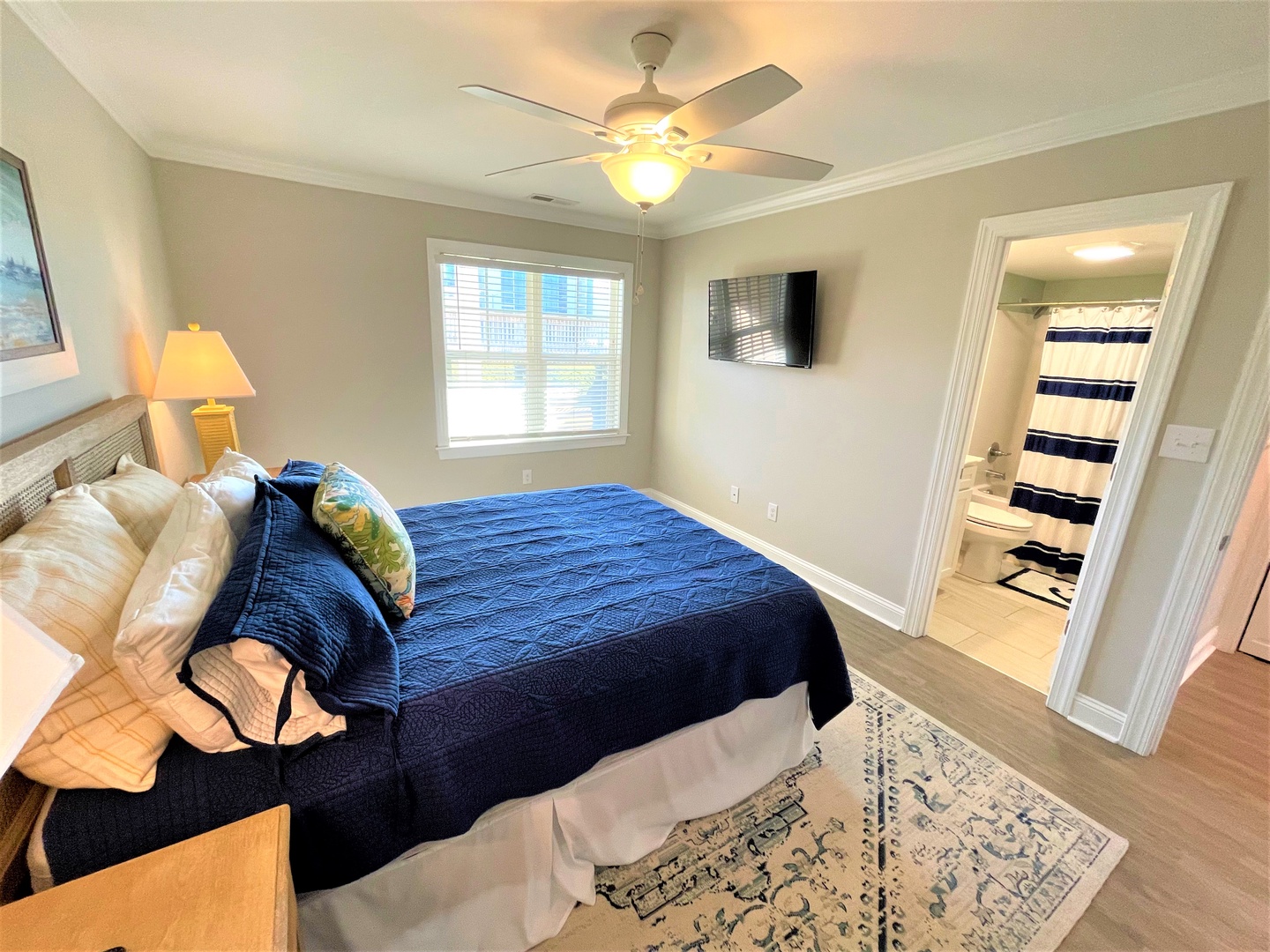 Unwind in your peaceful bedroom featuring a cozy queen bed, ceiling fan for comfort, and private ensuite bathroom.