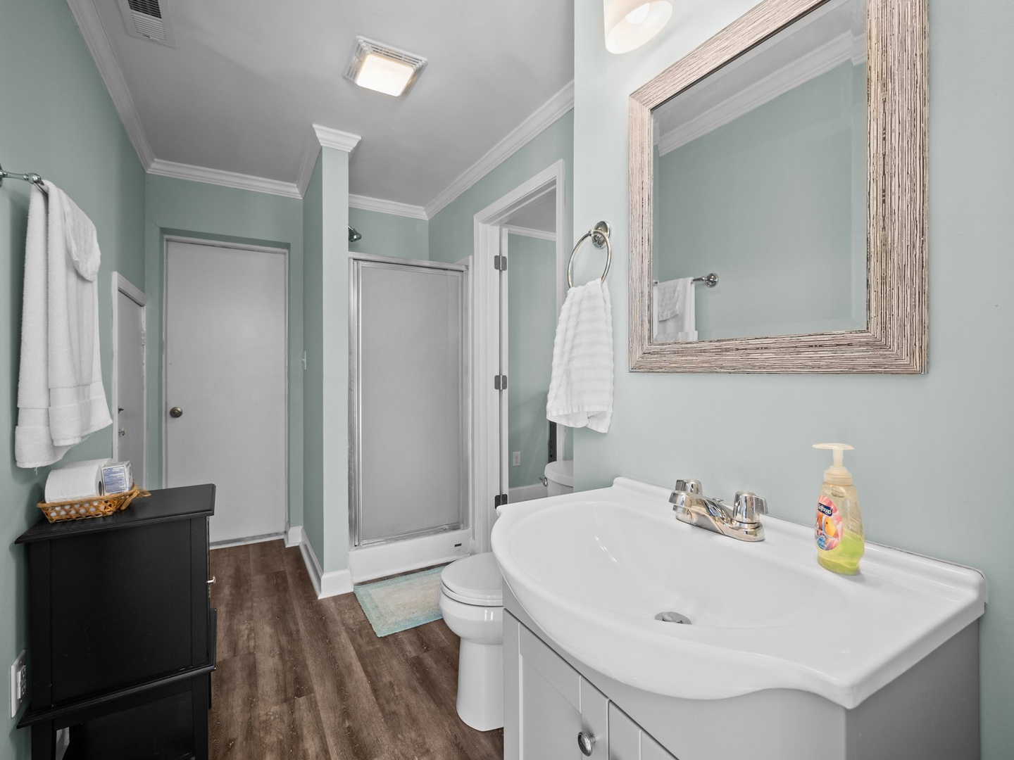 Refresh in your serene mint-green bathroom with fluffy towels, spacious vanity, and thoughtful amenities awaiting your arrival.