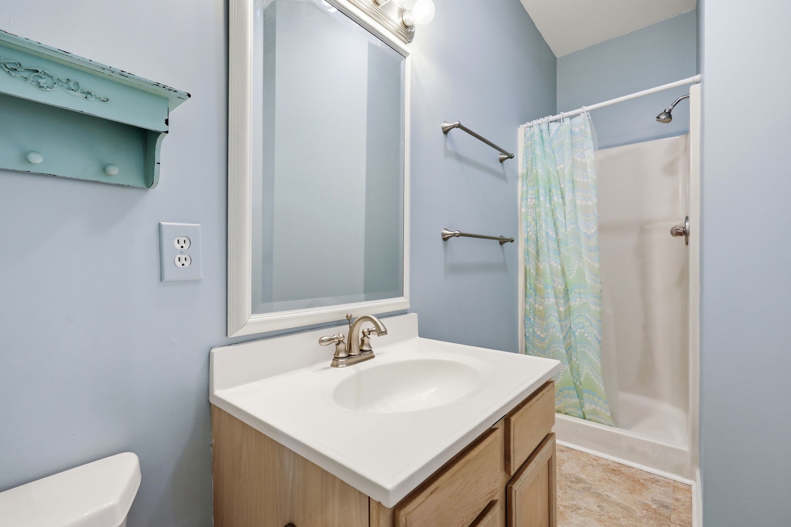 Freshen up in this light-filled bathroom with soothing blue tones, clean lines, and a convenient shower-tub combo—your peaceful retreat after a day of exploring.