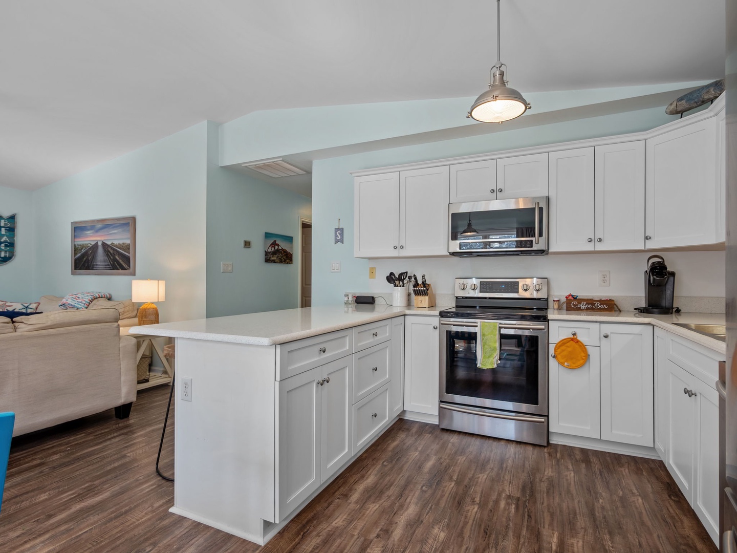 Your fully equipped kitchen features white cabinets, stainless steel appliances, and an open design that flows seamlessly into the living area.