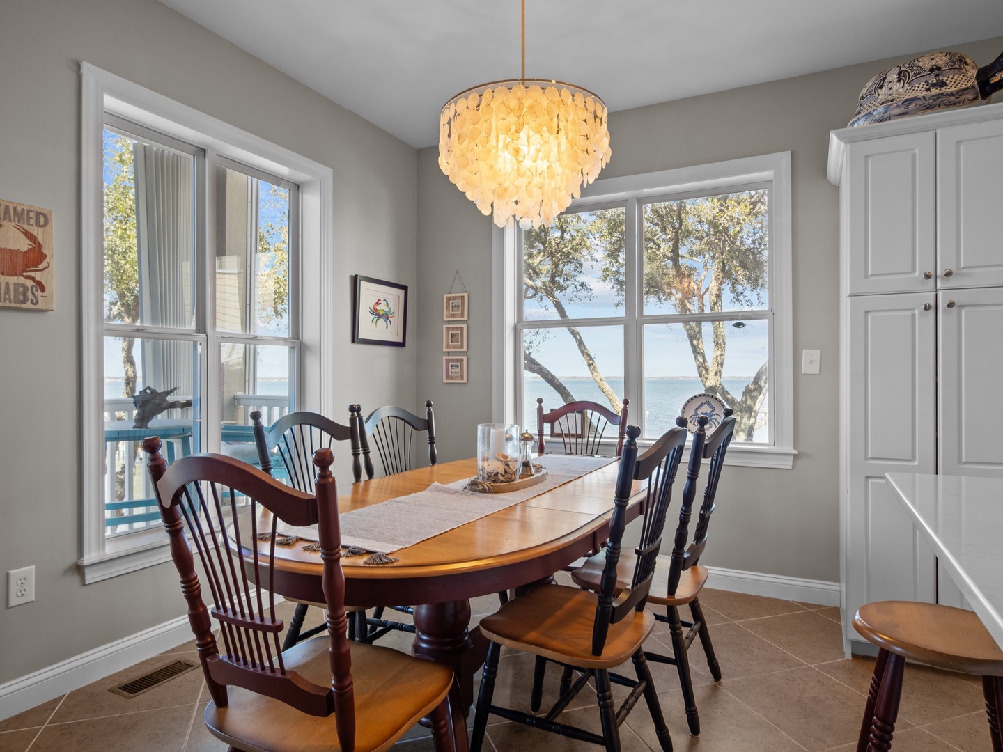 Gather around this warm dining table while soaking in stunning lake views through oversized windows, creating perfect moments for memorable meals.