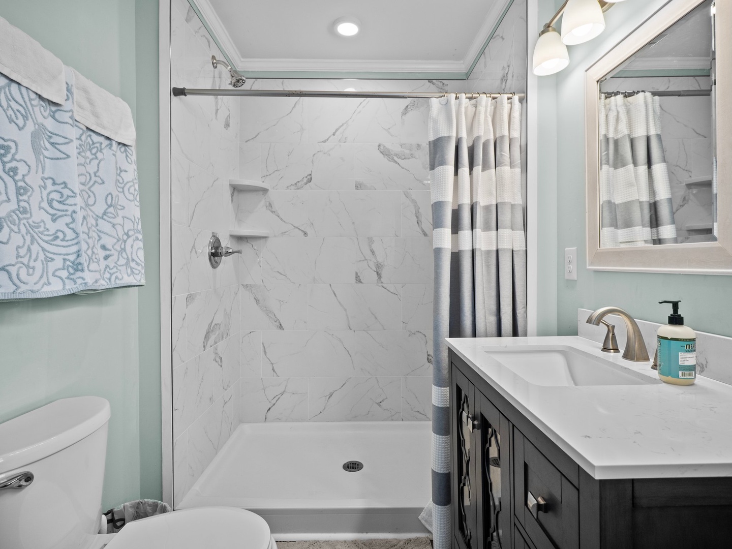 Step into your spa-like retreat with marble-inspired shower, soft mint walls, and premium fixtures creating a peaceful sanctuary.