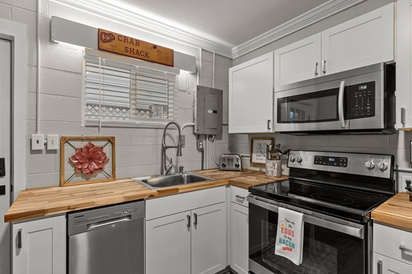 Your fully equipped kitchen awaits with warm wood countertops, stainless appliances, and charming coastal touches for memorable home-cooked meals.