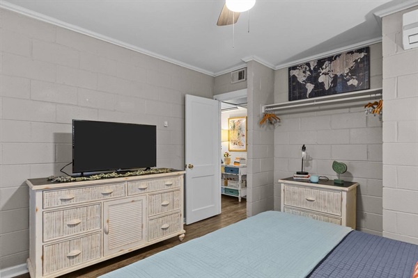 Relax in your peaceful bedroom featuring a large flatscreen TV, ample storage, and easy access to your private bathroom.