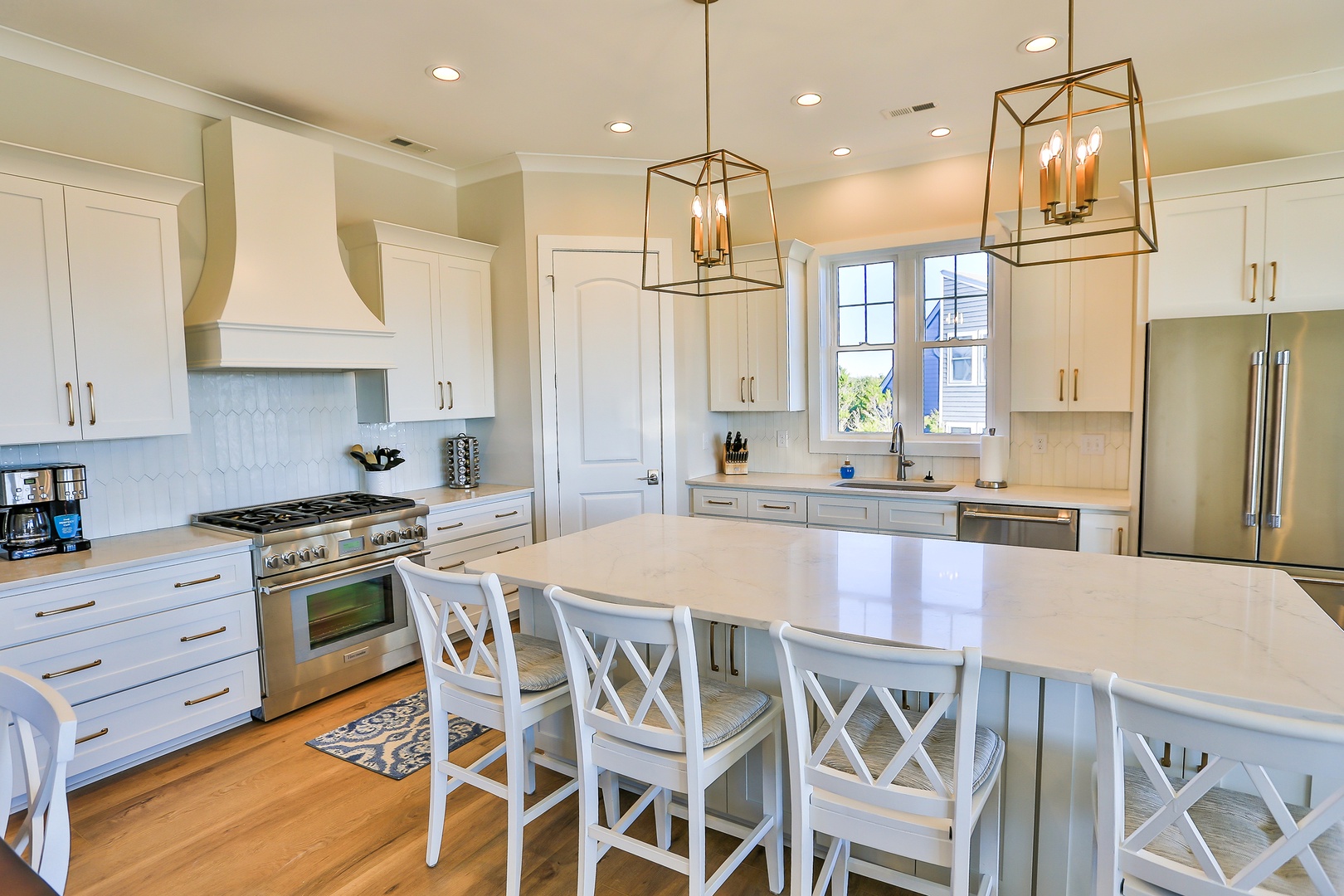 Your spacious gourmet kitchen features elegant white cabinetry, premium appliances, and a stunning island perfect for cooking memorable meals together.