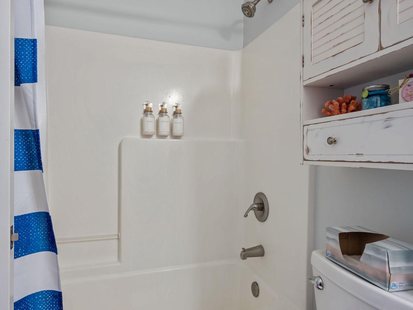 Refresh in your spa-like bathroom featuring a pristine tub-shower combo with convenient built-in storage and premium amenities.