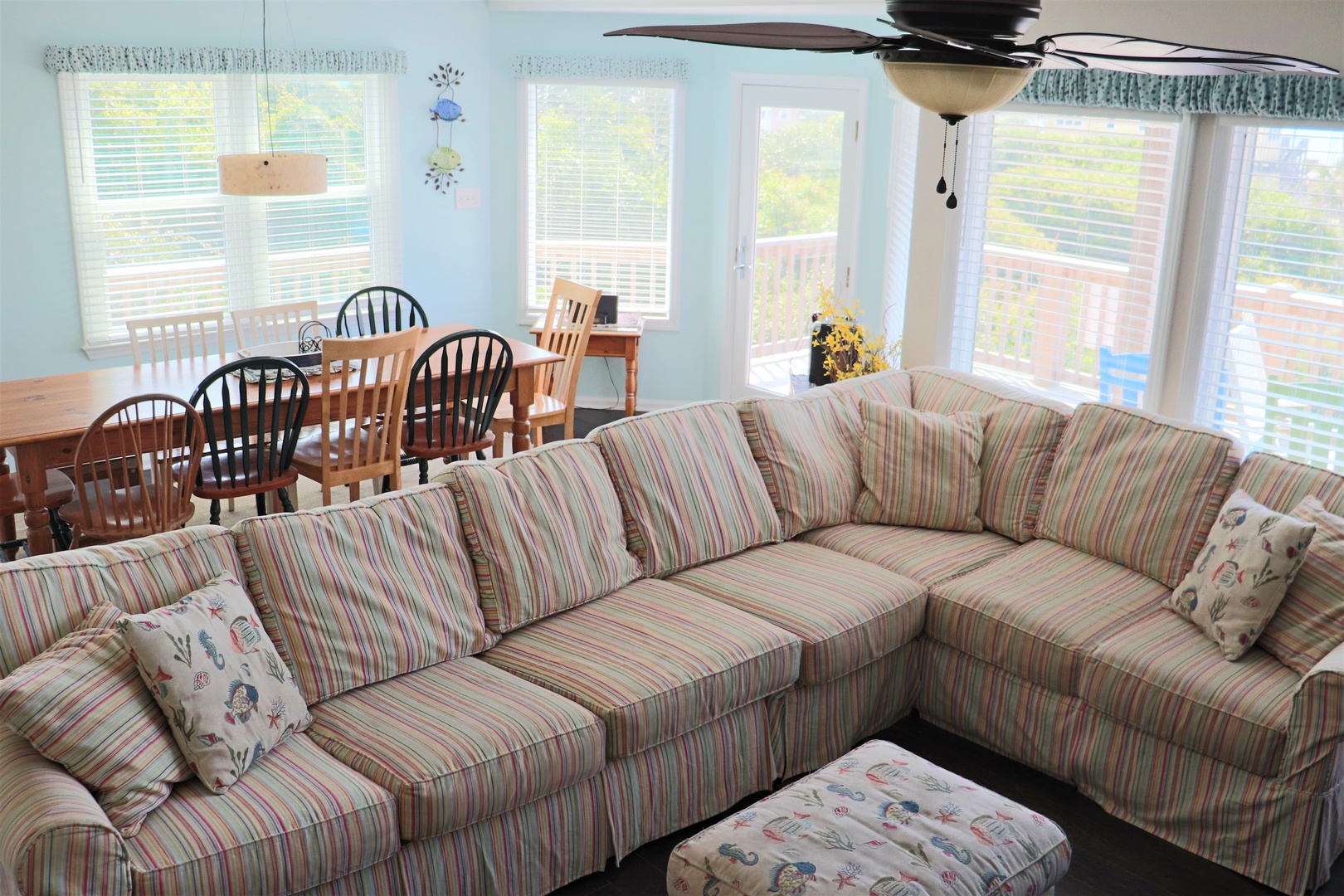 Relax on your spacious sectional sofa while enjoying natural light streaming through floor-to-ceiling windows in this bright, open living and dining space.