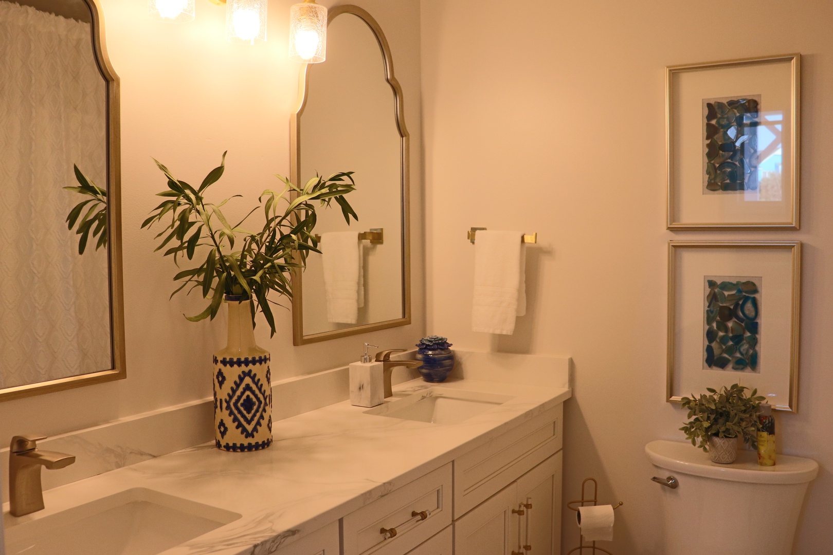 Refresh in your beautifully appointed bathroom featuring elegant dual vanities, decorative plants, and warm lighting for a spa-like experience.