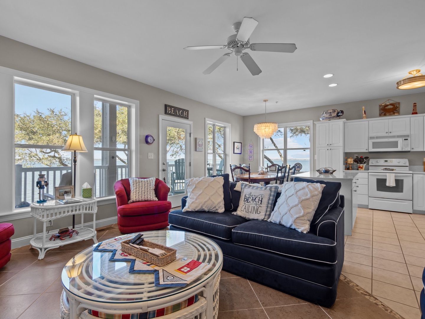 Unwind in your bright, coastal-themed living space where nautical decor and lake views create the perfect beach house atmosphere for relaxation.