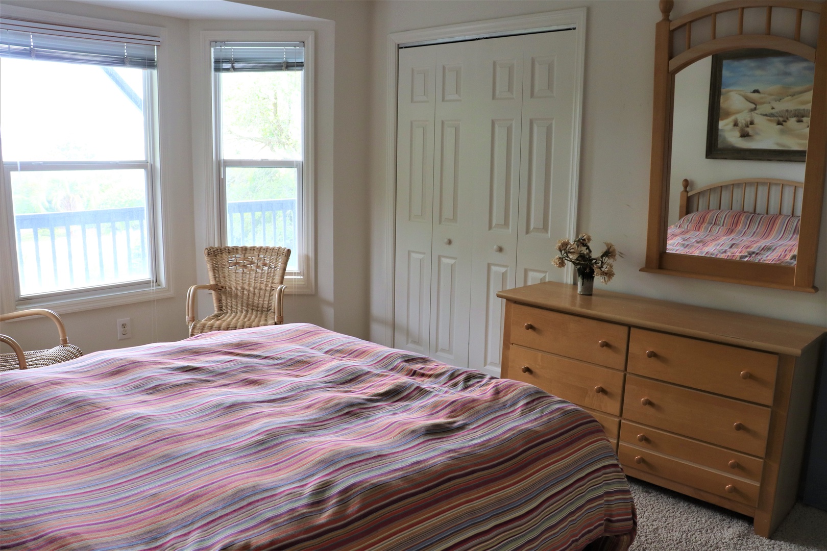 Unwind in your bright, airy bedroom with colorful linens, warm wood furnishings, and peaceful views.