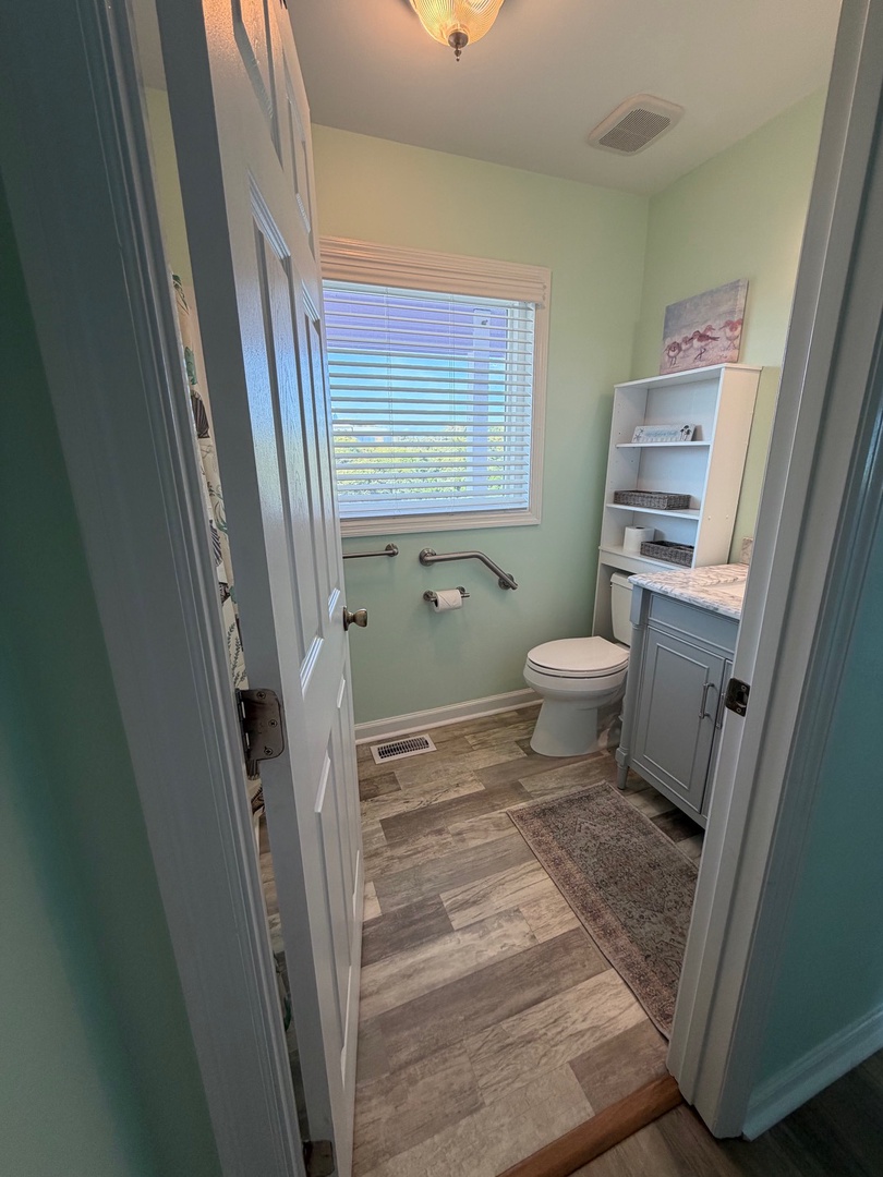 Your private bathroom features a spacious shower, modern fixtures, and wood-look flooring for your comfort.