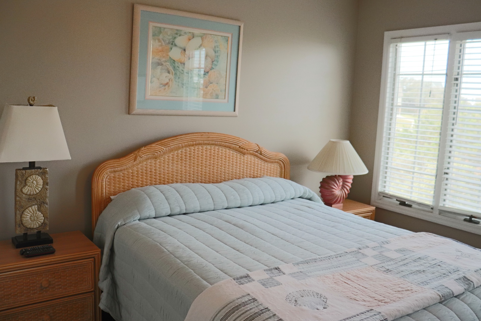 Wake up to gentle morning light streaming through your windows in this cozy bedroom with seashell-themed touches and coastal charm.