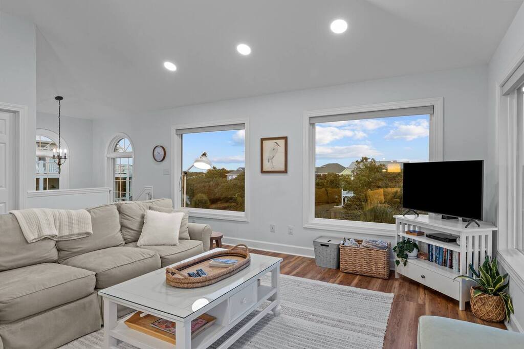 Relax in your bright living room with stunning mountain views through oversized windows and cozy seating for unwinding.