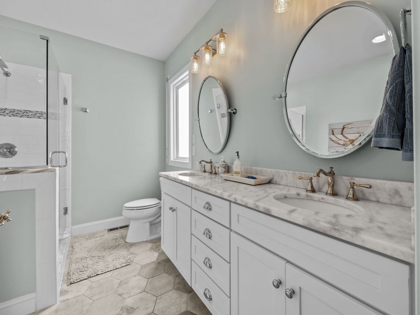 Step into your serene spa-like bathroom with dual vanities, marble countertops, and elegant lighting that creates the perfect morning routine.