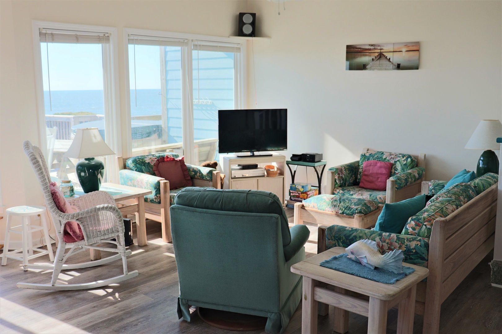 Settle into your bright oceanfront living room where waves meet horizon through panoramic windows, perfect for relaxing evenings with entertainment and sea views.