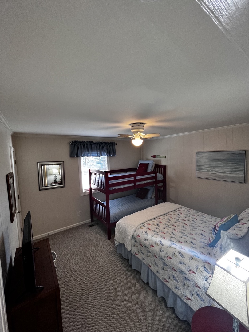 Your cozy bedroom features a comfortable bed with coastal-themed linens and warm lighting, creating the perfect retreat for restful nights.