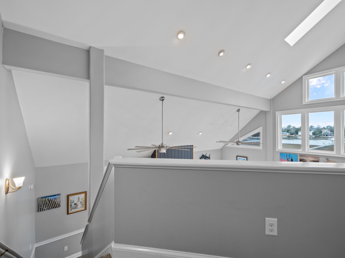 Bright open loft space with soaring ceilings and waterfront views through expansive windows.