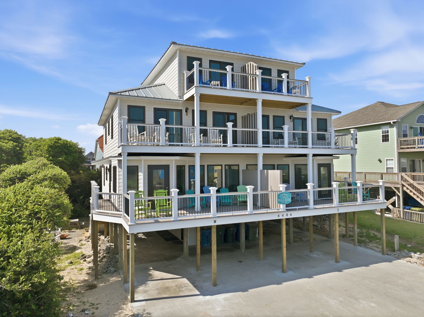 This spacious three-story coastal retreat offers multiple levels of waterfront living with wrap-around balconies, elevated parking, and easy beach access in a quiet neighborhood setting.