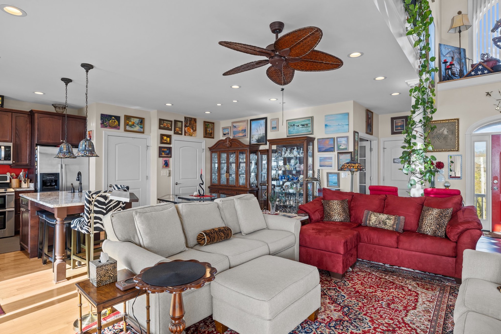 Relax in your spacious living room where comfortable seating meets stylish tropical ceiling fan and open kitchen views.