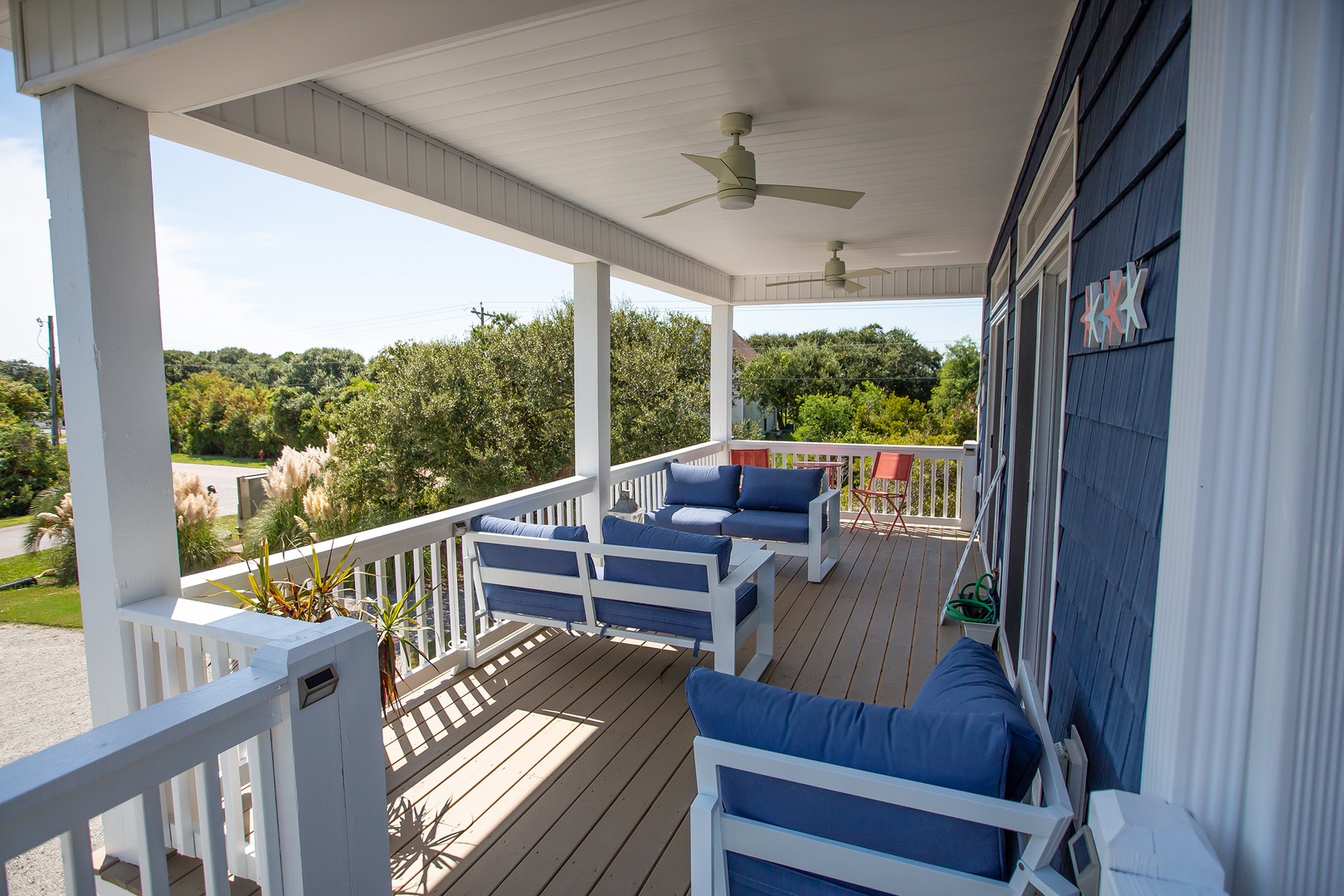 Unwind on your private covered deck with comfortable seating, ceiling fans, and peaceful tree-lined views stretching beyond.