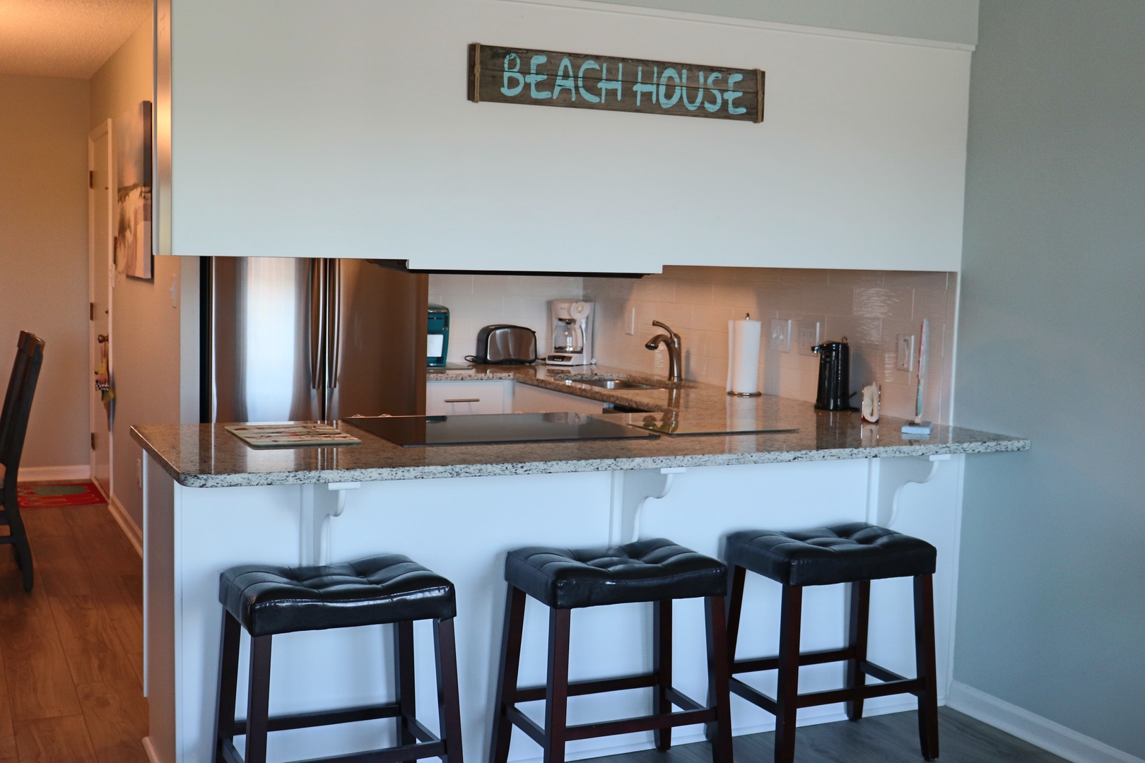 Your modern kitchen features granite counters and coastal charm with a breakfast bar perfect for morning coffee.