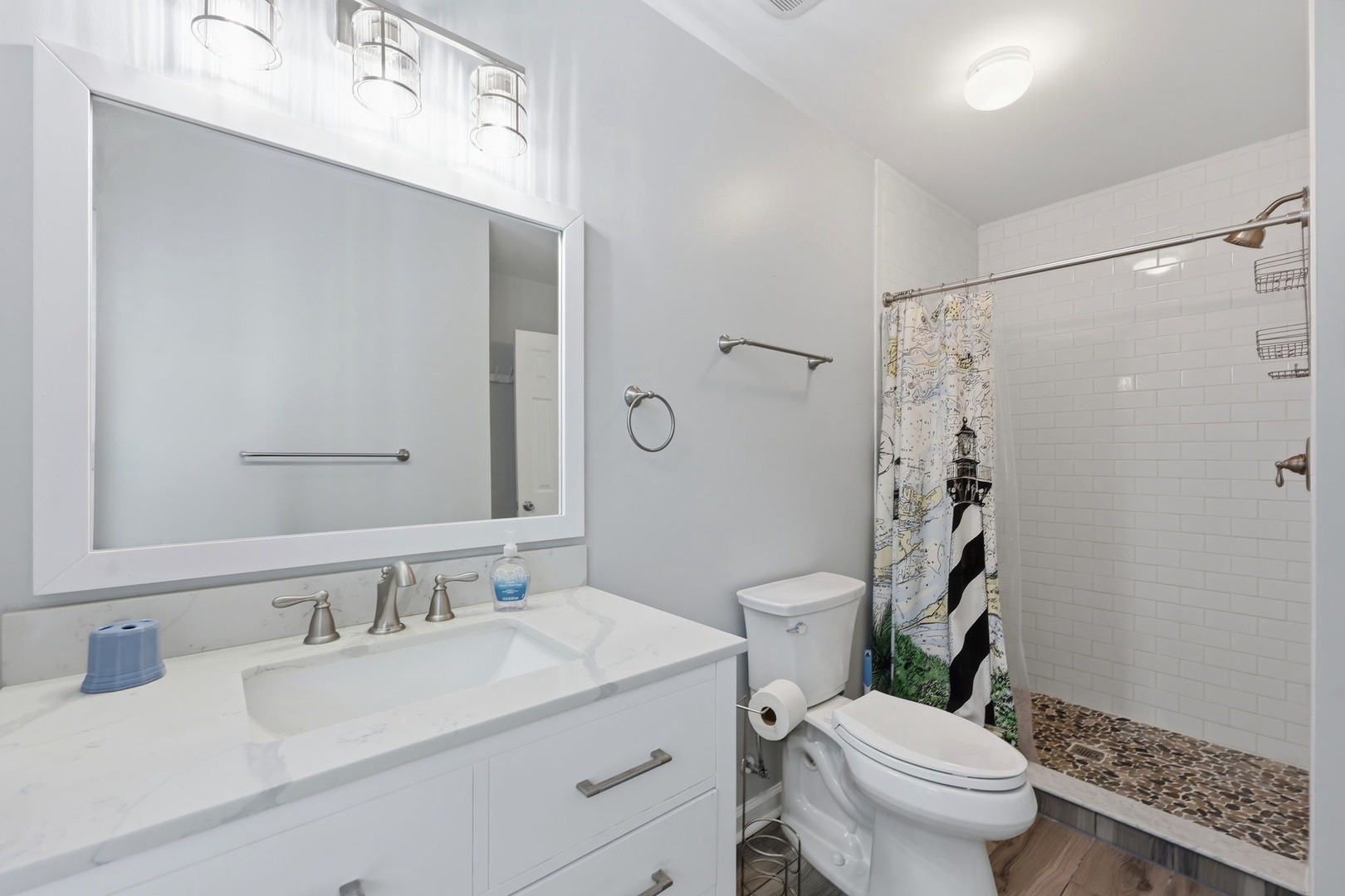 Step into a spotless, bright bathroom where coastal charm meets modern comfort. Fresh white subway tiles line your walk-in shower, while soft lighting creates a welcoming, spa-like ambiance perfect for unwinding.