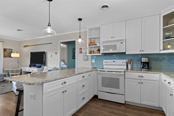 Your bright, fully-equipped kitchen features granite counters and modern appliances, seamlessly flowing into the living space for easy entertaining.