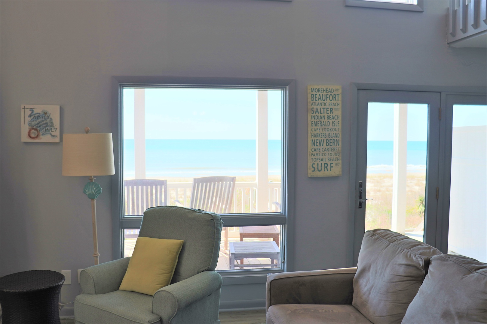 Sink into soft seating and gaze through panoramic windows at stunning ocean views and your private deck—pure coastal bliss awaits.