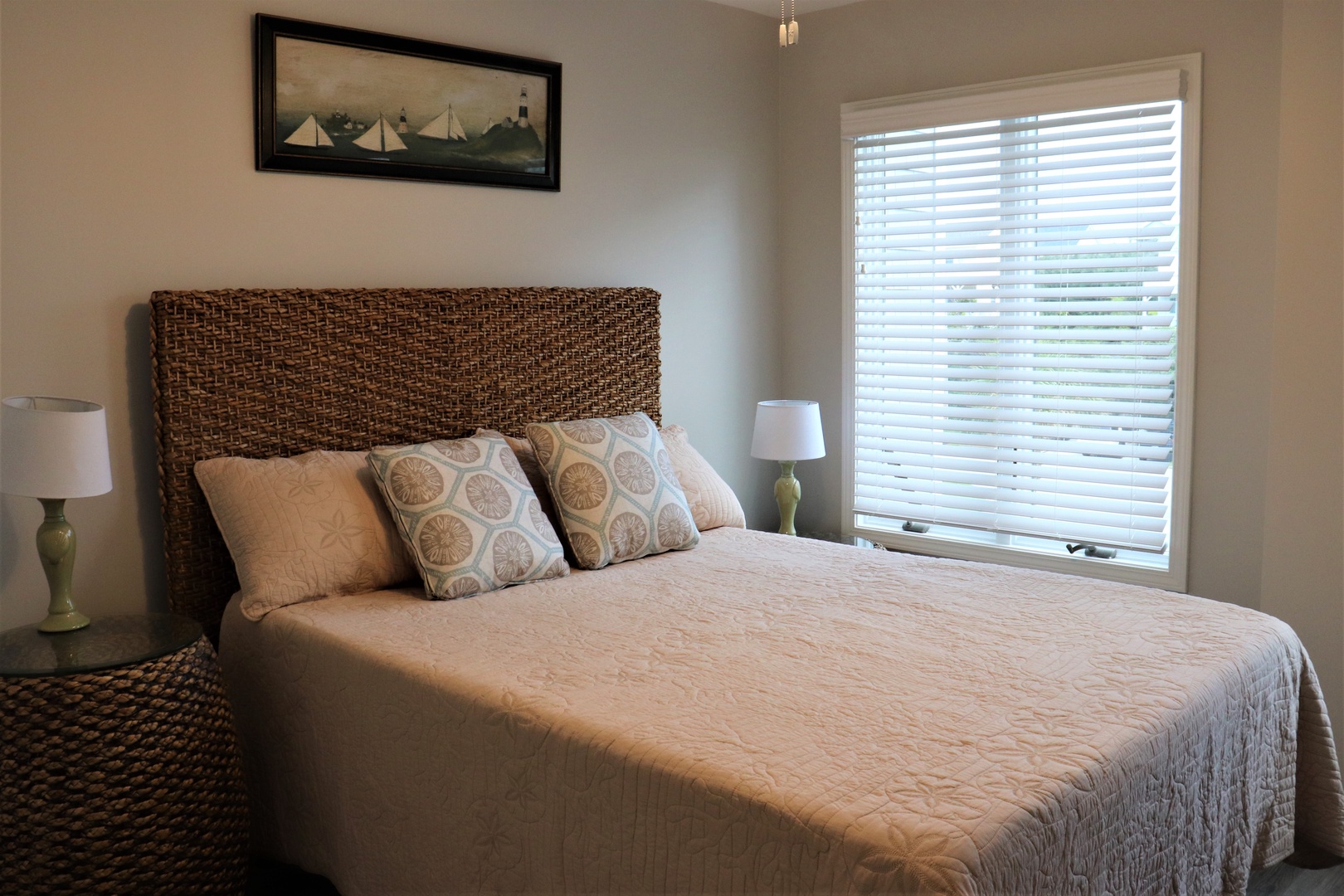 Unwind in your coastal-inspired bedroom featuring a woven headboard and soft nautical touches for peaceful nights.
