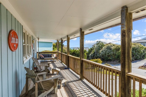 Relax on your covered porch with wooden seating where ocean breezes and peaceful views create the perfect spot for morning coffee.