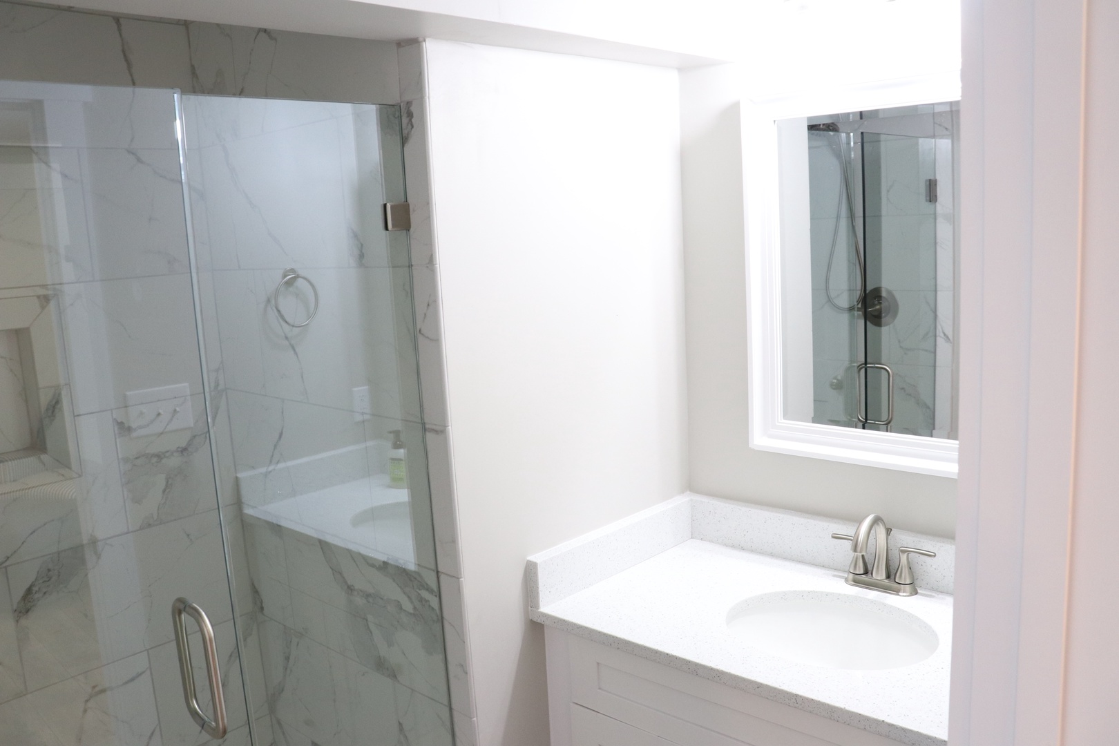 Step into your private spa-like retreat with gleaming marble finishes, a luxurious soaking tub, and spacious glass shower.