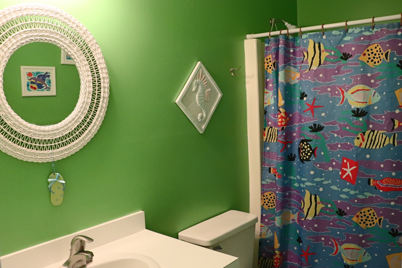 Bright green walls and whimsical ocean-themed decor create a cheerful bathroom where you'll enjoy getting ready each morning.