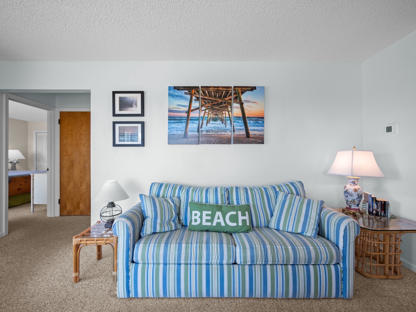 Cozy living room with beach-themed decor invites you to relax on the striped sofa after your seaside adventures.